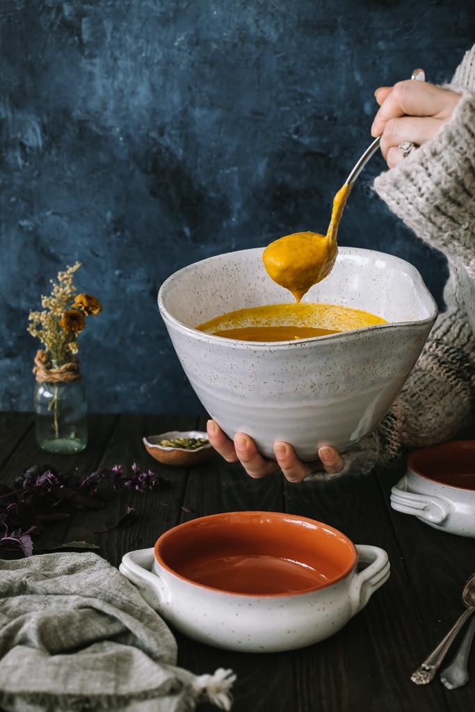 Vegan Butternut Squash and Apple Soup being ladled into a soup bowl