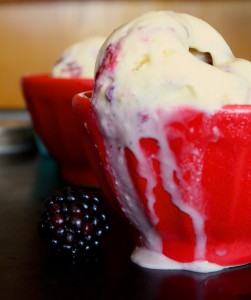 side view of a small bowl with sweet corn blackberry swirl ice cream