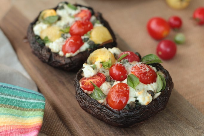 Goat Cheese stuffed Portobello mushroom cap Pizzas with cherry tomatoes basil and spinach 