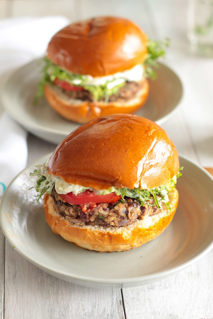 two Glutenfree Black Bean Shiitake Burgers with lettuce and tomatoes 