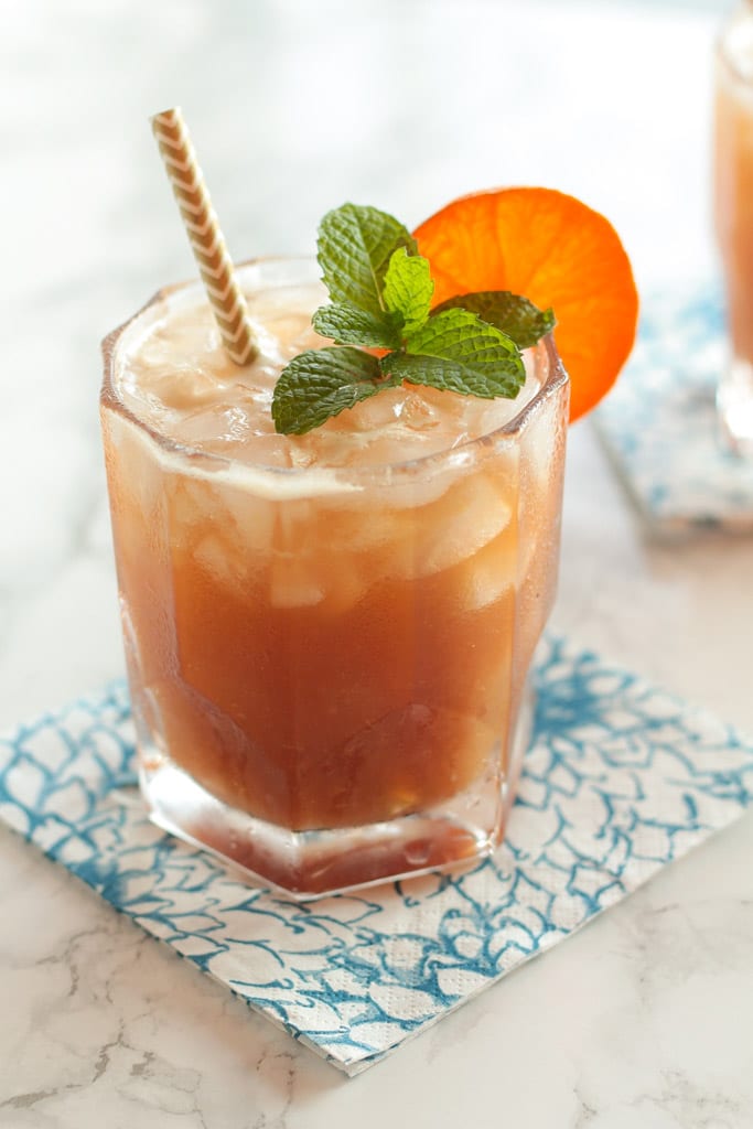 tangerine kombucha mai tai cocktail with fresh mint and a tangerine slice