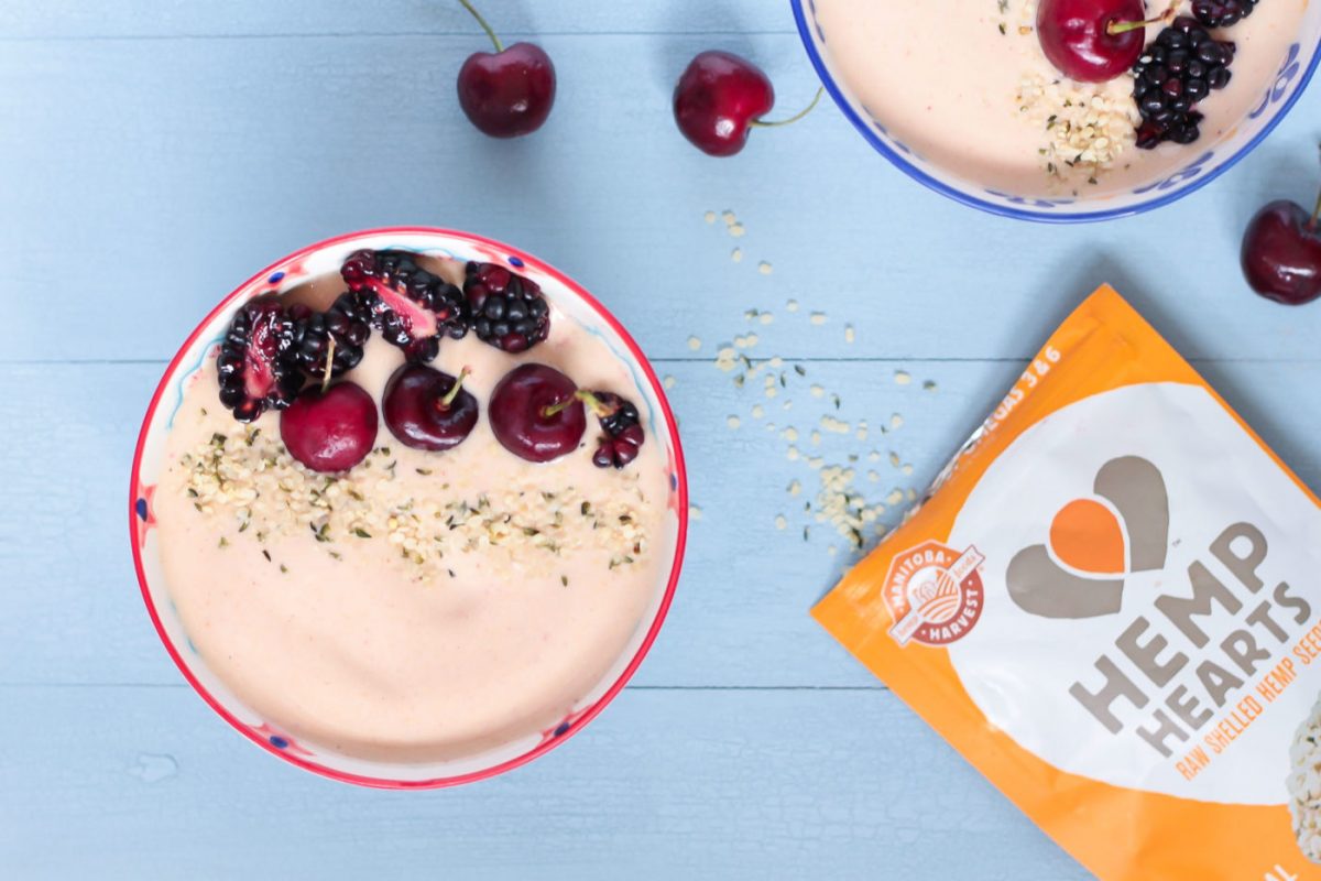 a healthy Peanut Butter & Jelly Smoothie Bowl with protein powder next to a pack of hemp seeds