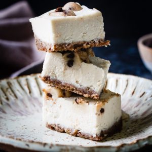 chocolate chip cookie dough cheesecake bars stacked on a plate