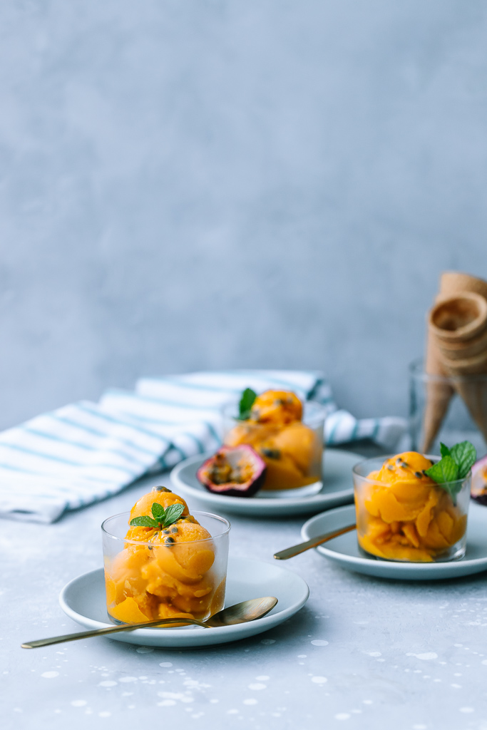 Scoops of Mango Passion Fruit Sorbet with fresh mint and passion fruit