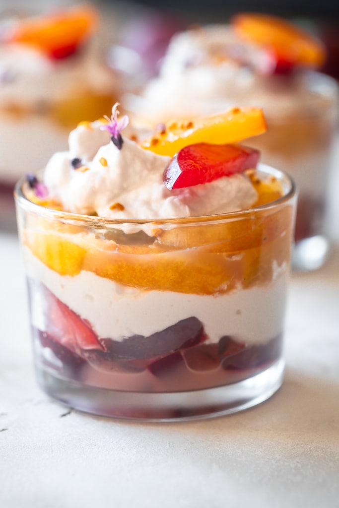 poached plum coconut cream parfaits in clear glass jars