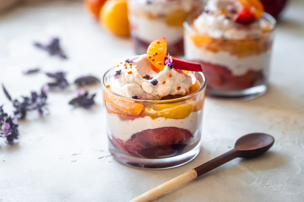 poached plum coconut cream parfaits in clear glass jars