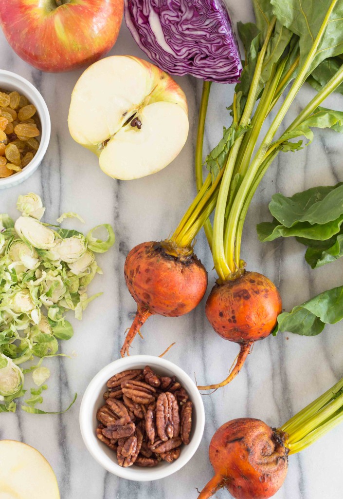 vegetables needed for making brussles sprouts slaw on a marble countertop 