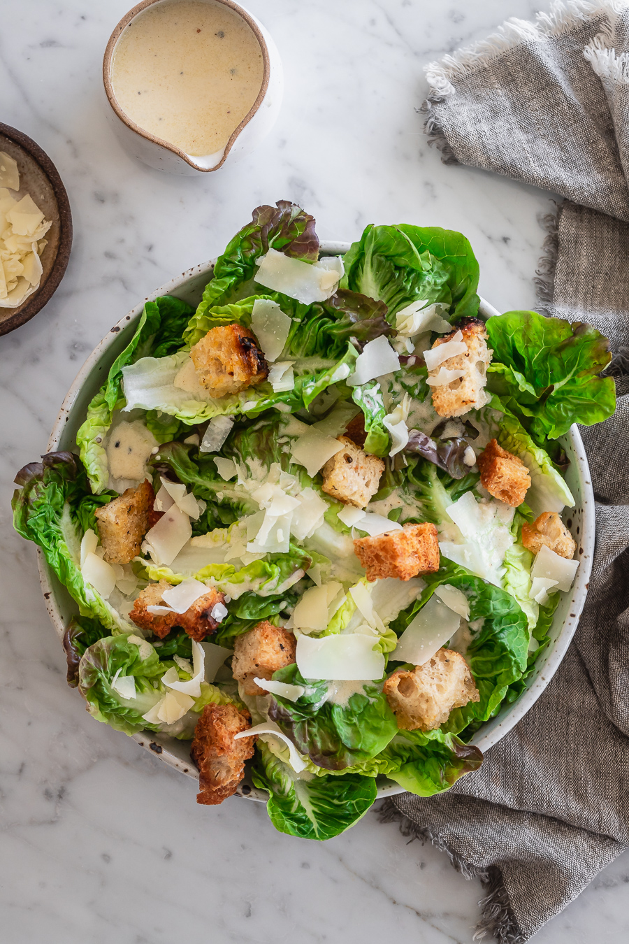 A bowl of Caesar Salad with shaved parmesan and croutons