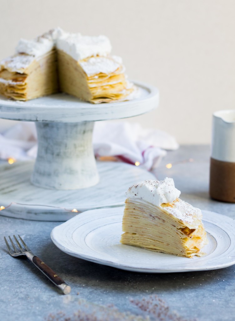 a slice of Eggnog Crepe Cake aka. mille crepe cake on a white plate