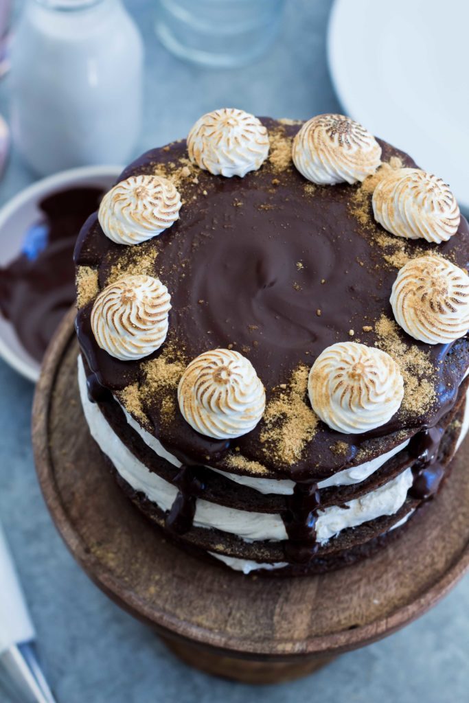 overhead shot of a layered Chocolate S'mores Cake topped with chocolate ganache and toasted marshmallow fluff swirls