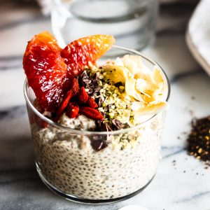 A glass jar of coconut chai chia pudding with toppings
