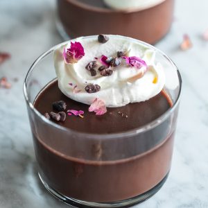 chocolate bourbon pot de creme with whipped cream and rose petals