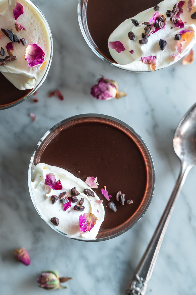 overhead shot of three jars of dairy-free chocolate pots de creme with rose petals