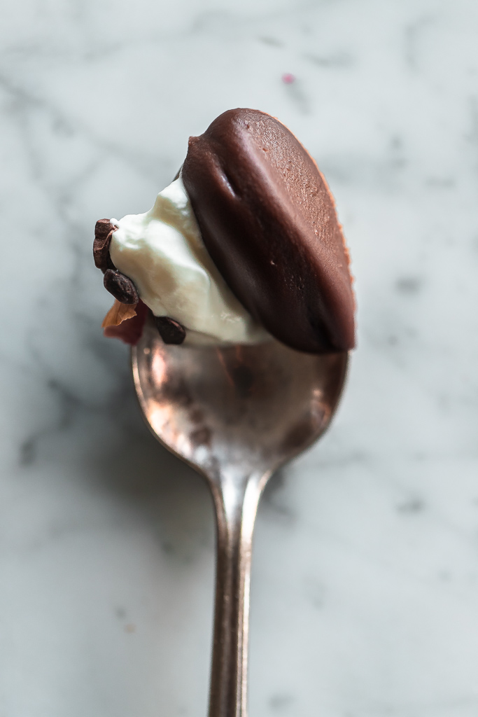 spoonful of chocolate bourbon pots de cremes with coconut whipped cream