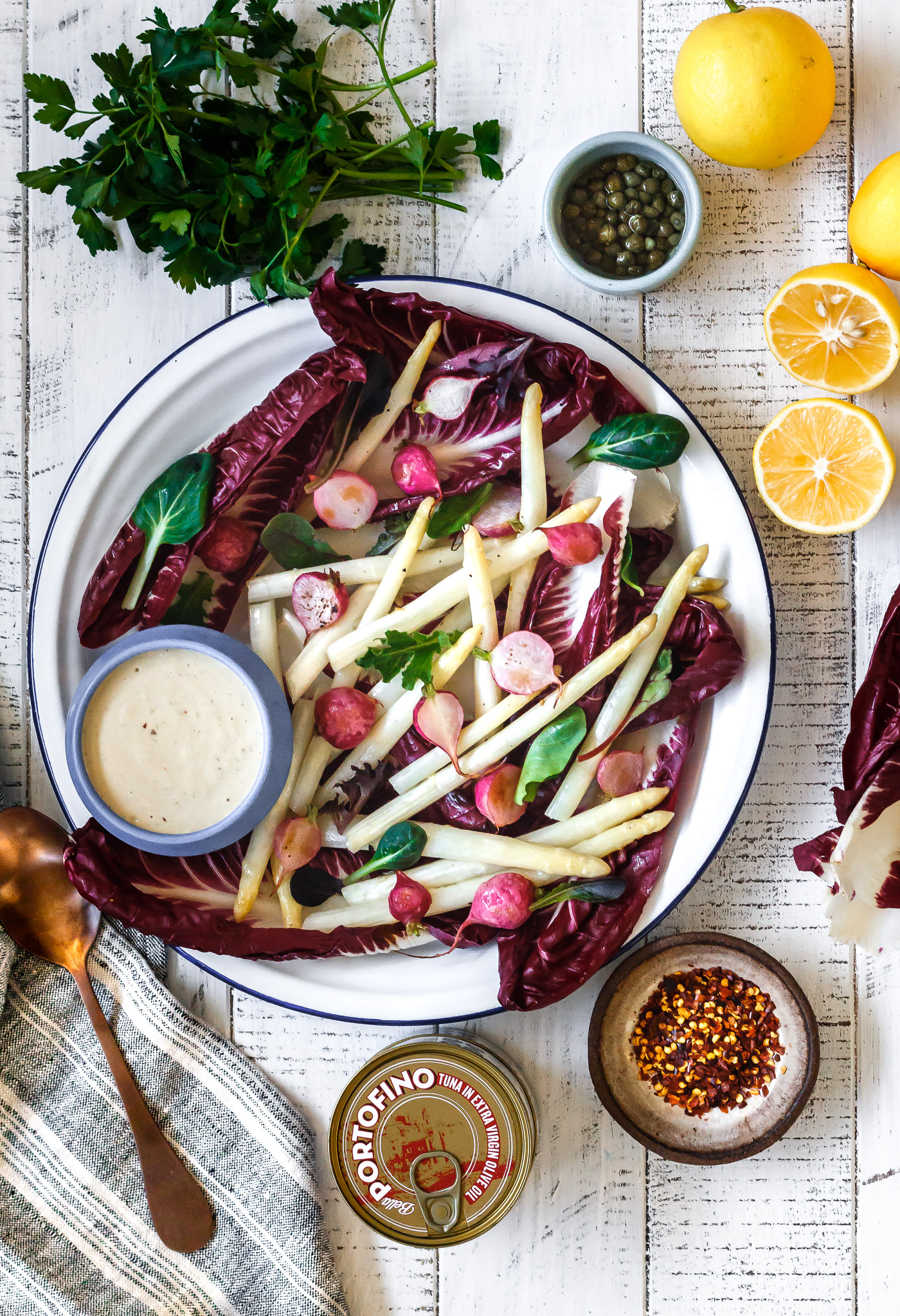 Meyer Lemon & Chile Tonnato Sauce in a bowl next to platter of white asparagus, treviso and roasted radish