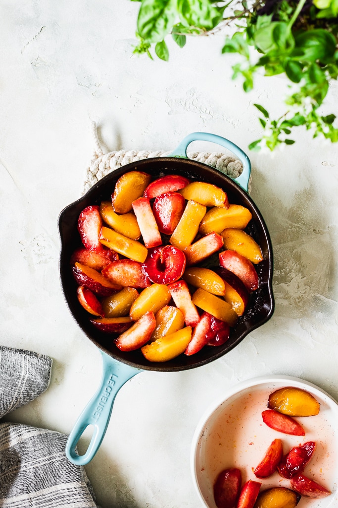 Easy Plum Tarte Tatin being assembled in a blue skillet