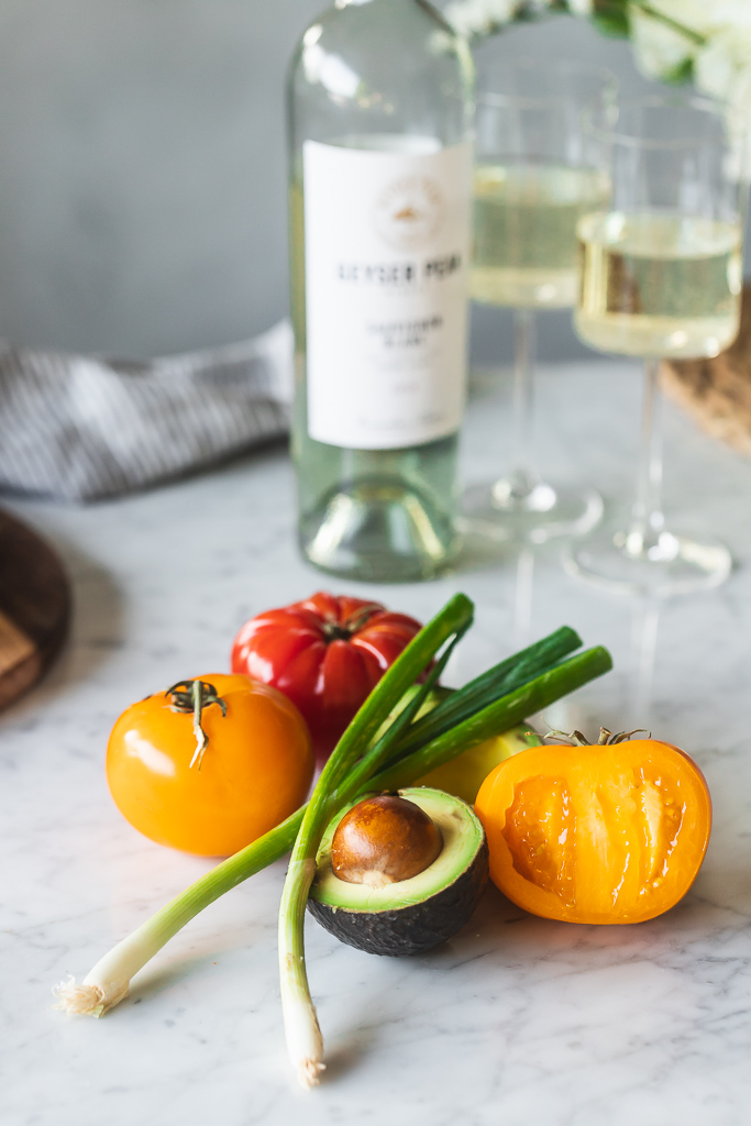 heirloom tomatoes, scallions and avocado on a marble counter