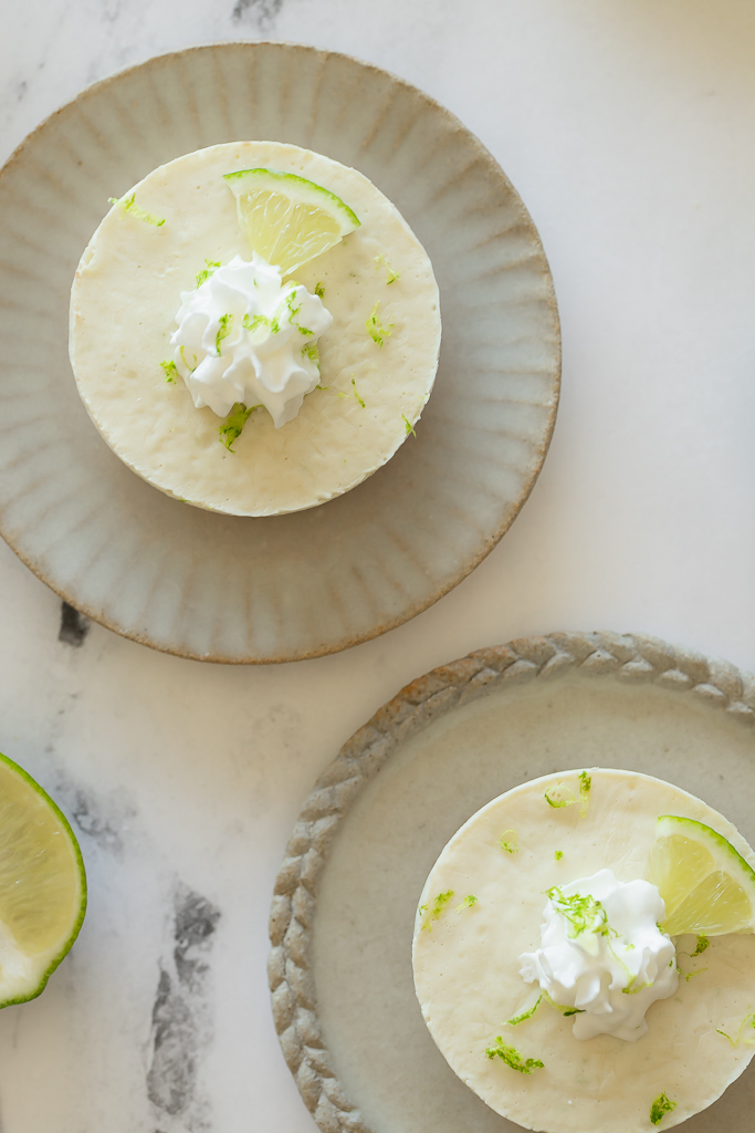 vegan margarita cheesecake topped with lime wedge, zest and whipped cream