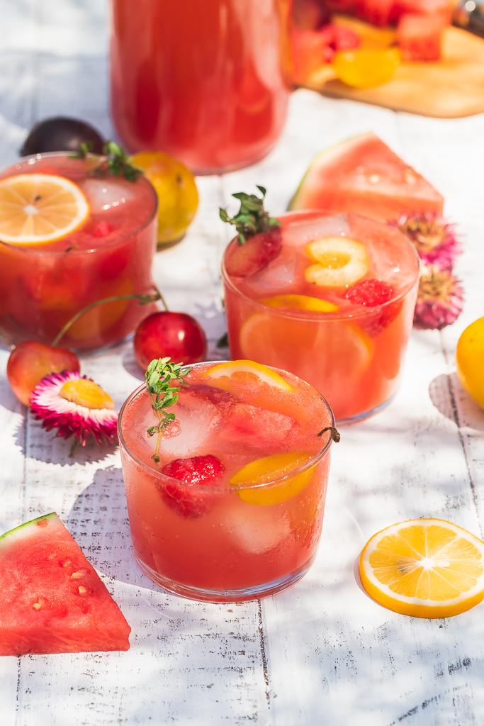 two glasses of sugar-free healthy watermelon rose sangria with watermelon chunks and other sliced fruit