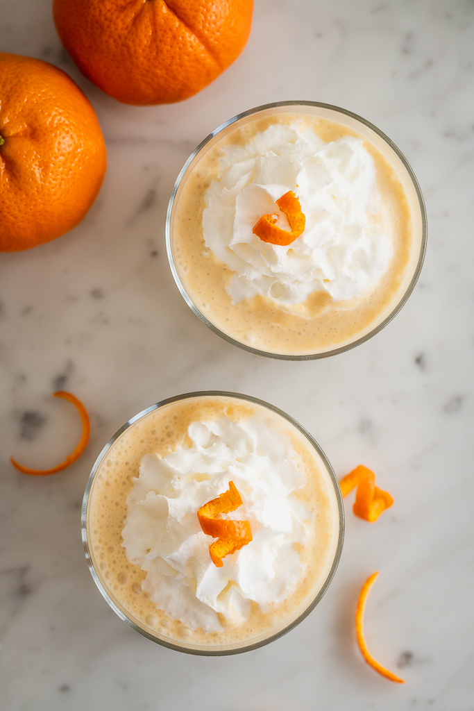 orange vanilla smoothies with whipped cream and orange peel curl garnish