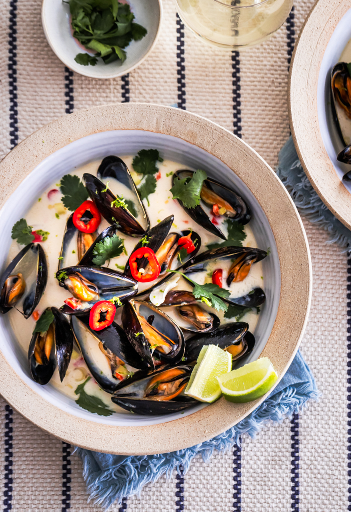 Lemongrass mussels with red thai chile and cilantro in a coconut broth served in a stoneware bowl