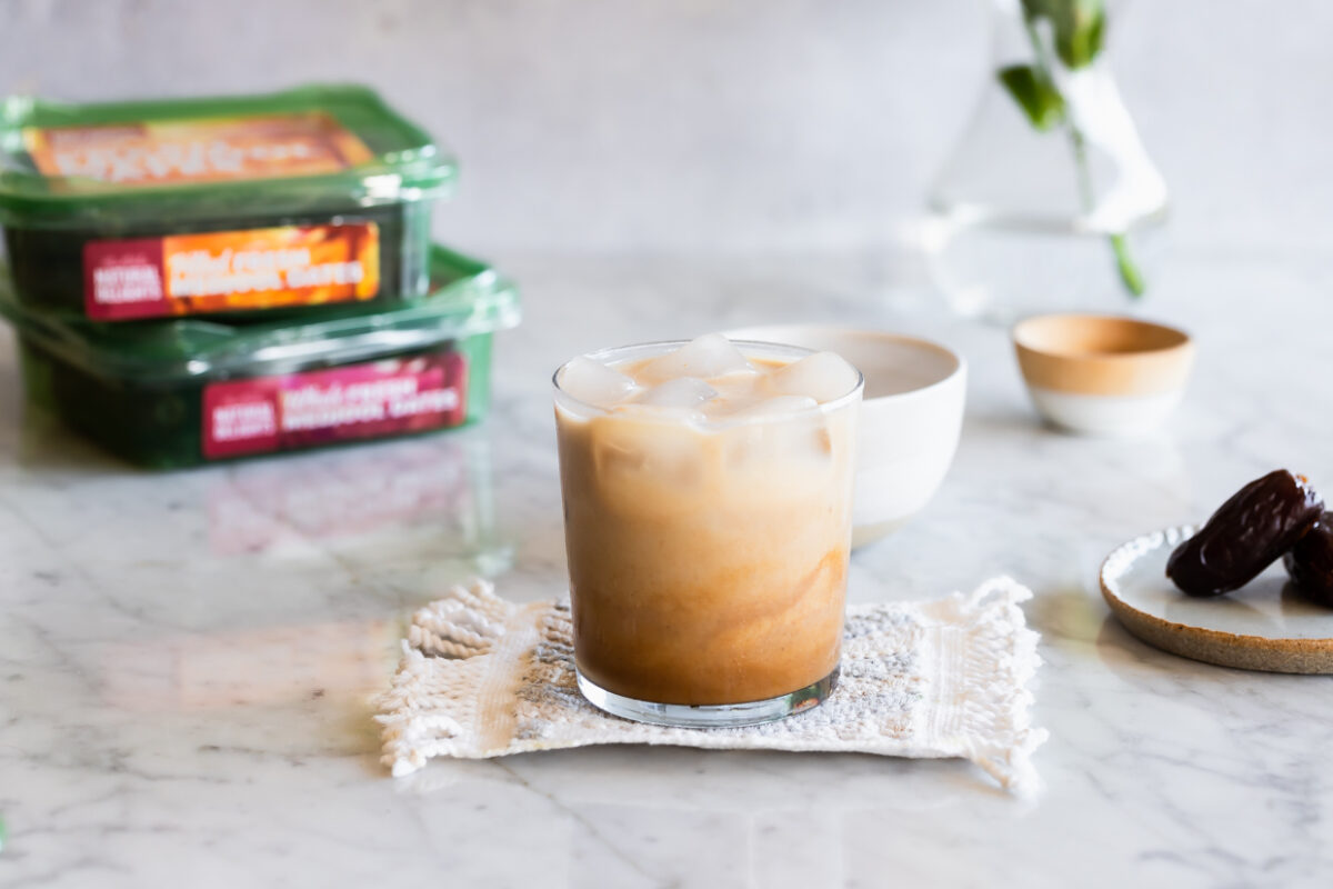 iced caramel latte with packages of dates in the background